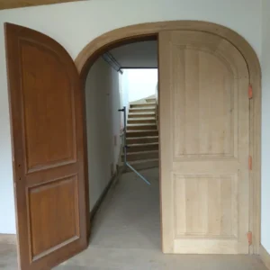 Comparaison porte en bois avant et après aérogommage dans une maison en rénovation, montrant le décapage et la remise à nu du bois