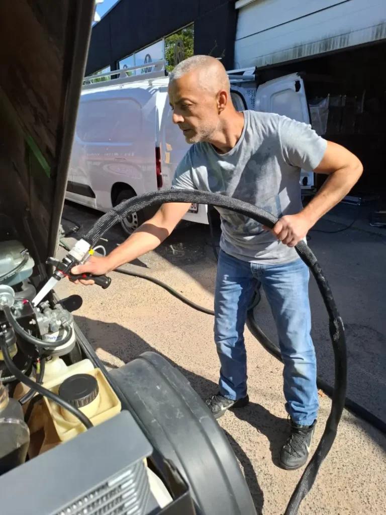 Technicien réalisant une opération de nettoyage industriel avec équipement haute pression sur un chantier professionnel