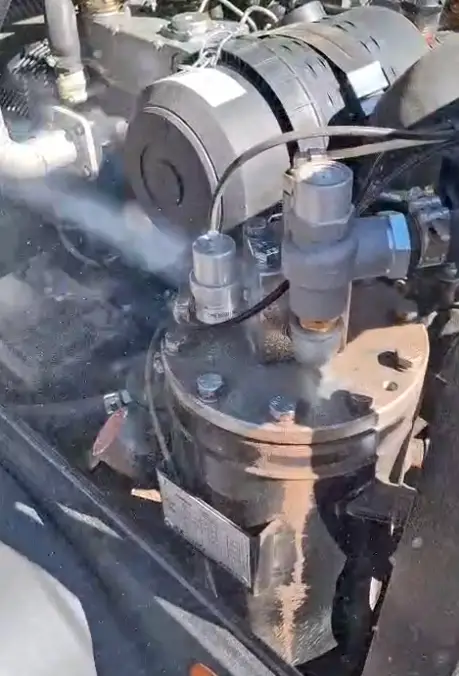Technicien de nettoyage industriel manipulant une machine de nettoyage cryogénique CRYANOMIC. L'image montre l'équipement mobile avec une buse et un tuyau de sablage à la glace carbonique sur un sol d'usine.